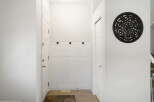 Step into this inviting entryway, featuring a stylish coat rack and a decorative wall accent.