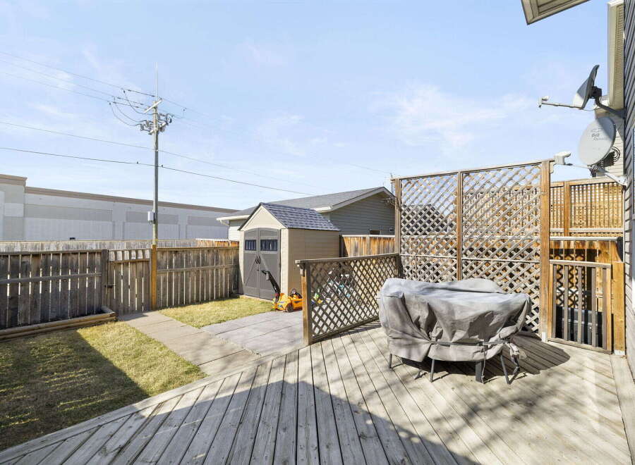 Enjoy outdoor living in this charming backyard! Featuring a spacious wooden deck, perfect for entertaining or relaxing.