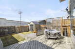 Enjoy outdoor living in this charming backyard! Featuring a spacious wooden deck, perfect for entertaining or relaxing.