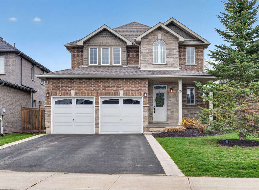 This stunning two-story home boasts a beautiful brick facade and a welcoming front porch.