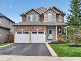 This stunning two-story home boasts a beautiful brick facade and a welcoming front porch.