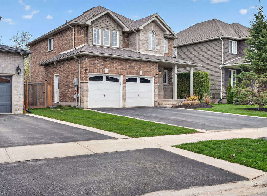 This stunning two-story home boasts a beautiful brick exterior and a well-manicured lawn, perfect for curb appeal.
