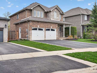 This stunning two-story home boasts a beautiful brick exterior and a well-manicured lawn, perfect for curb appeal.