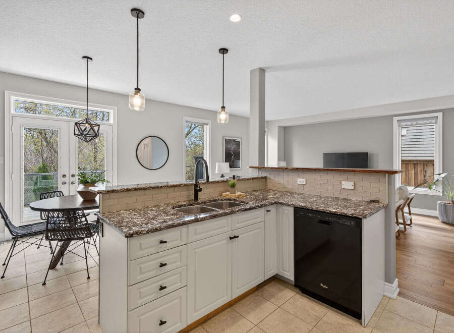 Step into this stunning kitchen, featuring elegant granite countertops and modern appliances.