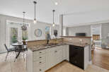 Step into this stunning kitchen, featuring elegant granite countertops and modern appliances.