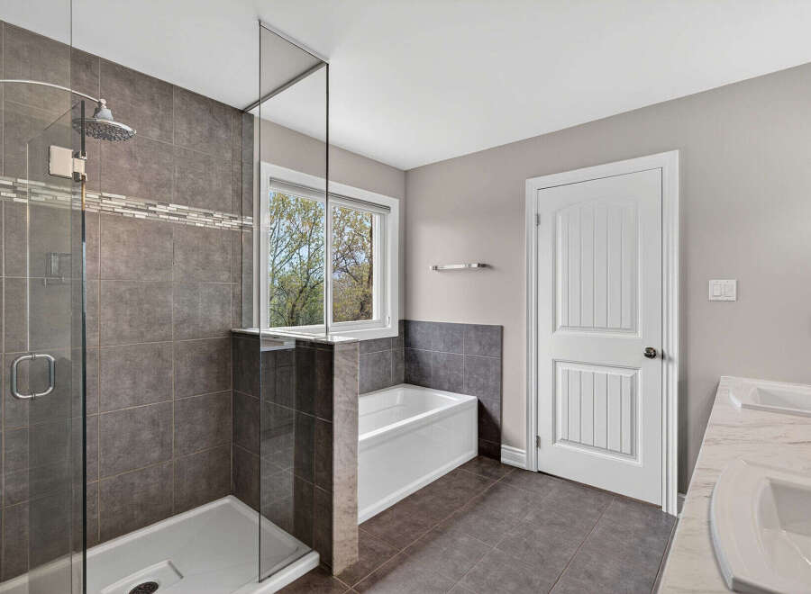 Step into luxury with this stunning bathroom! Featuring a modern walk-in shower with sleek glass doors and elegant tile work, this space is designed for relaxation.