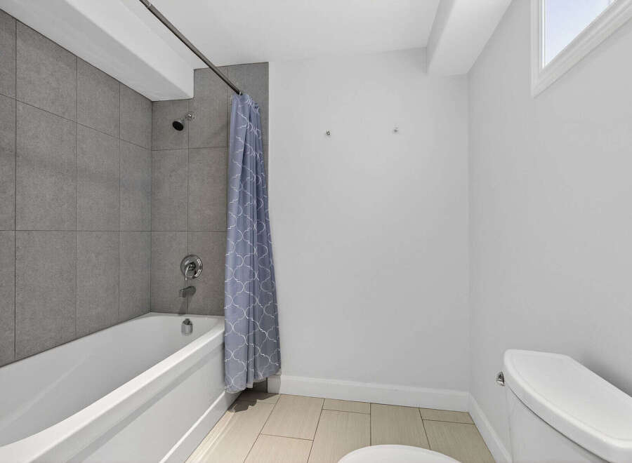 Step into a modern bathroom featuring a sleek bathtub and a stylish shower curtain.