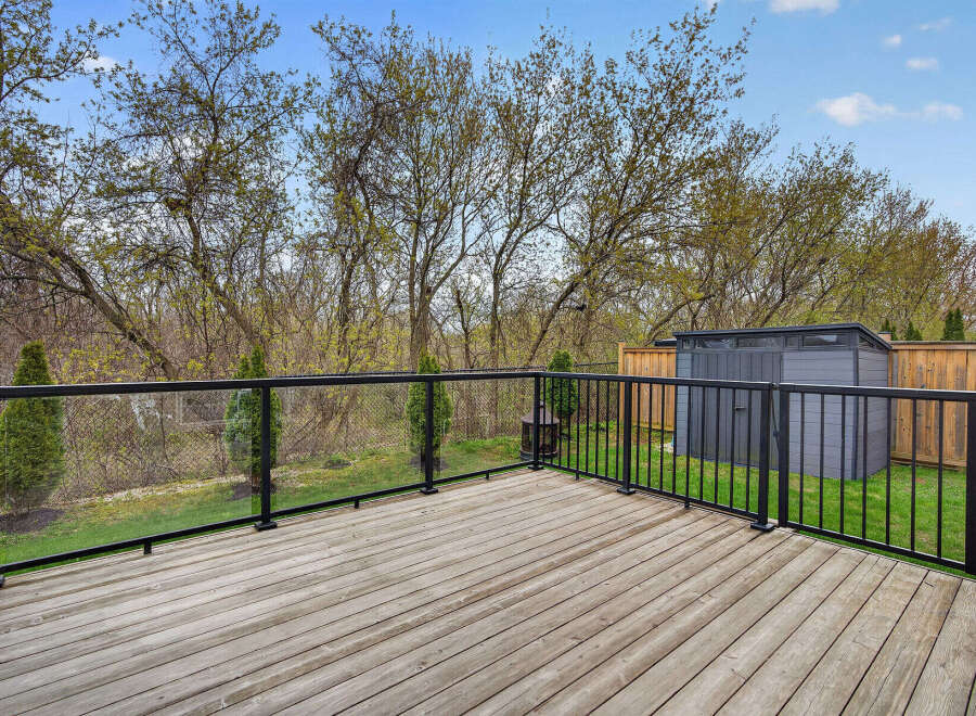 Enjoy outdoor living at its finest with this stunning deck! The deck features a modern glass railing, offering unobstructed views of the lush backyard.