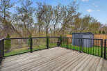 Enjoy outdoor living at its finest with this stunning deck! The deck features a modern glass railing, offering unobstructed views of the lush backyard.