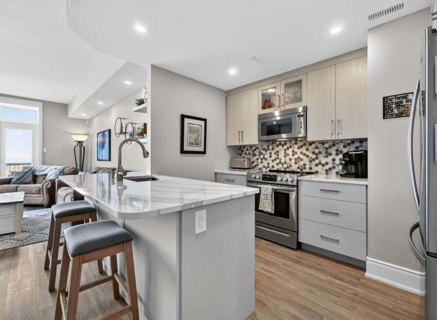 This stunning kitchen boasts modern design with sleek cabinetry and a beautiful marble countertop island, perfect for both cooking and entertaining.