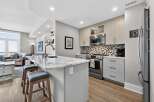 This stunning kitchen boasts modern design with sleek cabinetry and a beautiful marble countertop island, perfect for both cooking and entertaining.