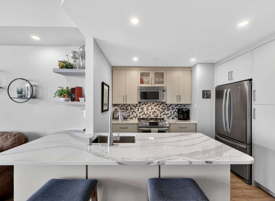 This stunning kitchen boasts a modern design with sleek countertops and ample storage.