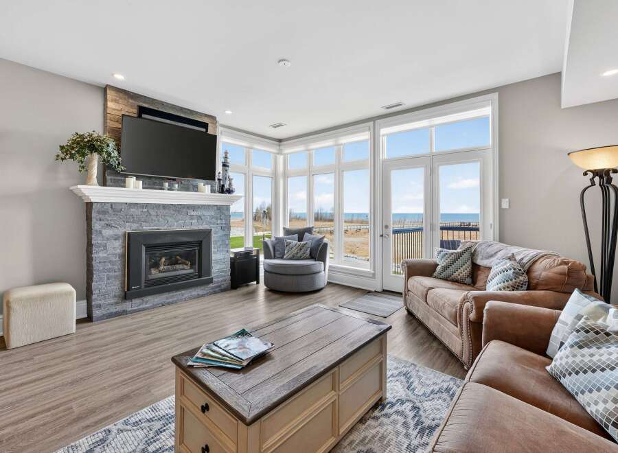 This stunning living room boasts a cozy fireplace and a large TV, perfect for relaxing evenings.