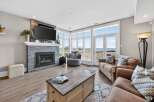 This stunning living room boasts a cozy fireplace and a large TV, perfect for relaxing evenings.