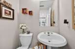 This charming powder room features a pedestal sink, perfect for guests.