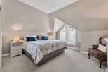 This stunning bedroom boasts a unique architectural design with a sloped ceiling and a striking triangular window.