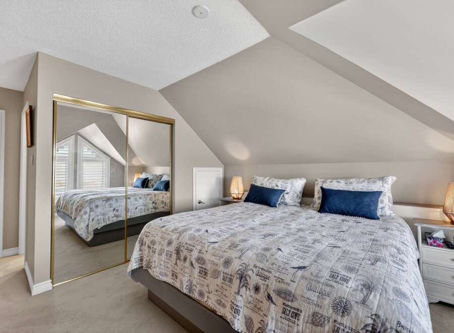 Discover the charm of this cozy bedroom, featuring a unique sloped ceiling and ample natural light.