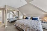 Discover the charm of this cozy bedroom, featuring a unique sloped ceiling and ample natural light.