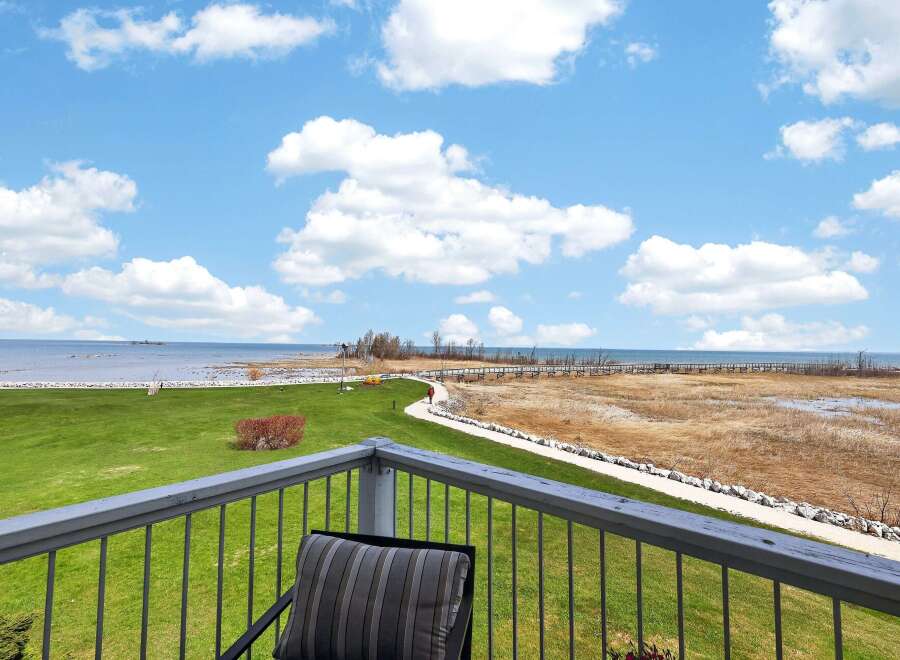 Enjoy breathtaking views from this stunning property! This home features a spacious balcony overlooking a lush green lawn, a serene pathway, and the tranquil waters of the lake.