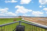 Enjoy breathtaking views from this stunning property! This home features a spacious balcony overlooking a lush green lawn, a serene pathway, and the tranquil waters of the lake.