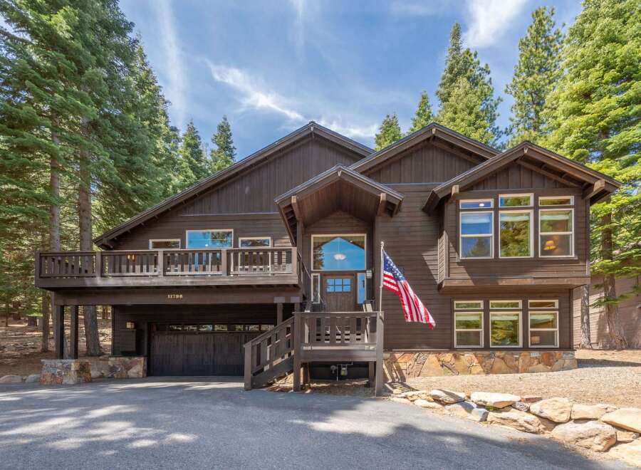 This stunning property boasts a beautiful exterior with a charming wooden design and an inviting entrance.