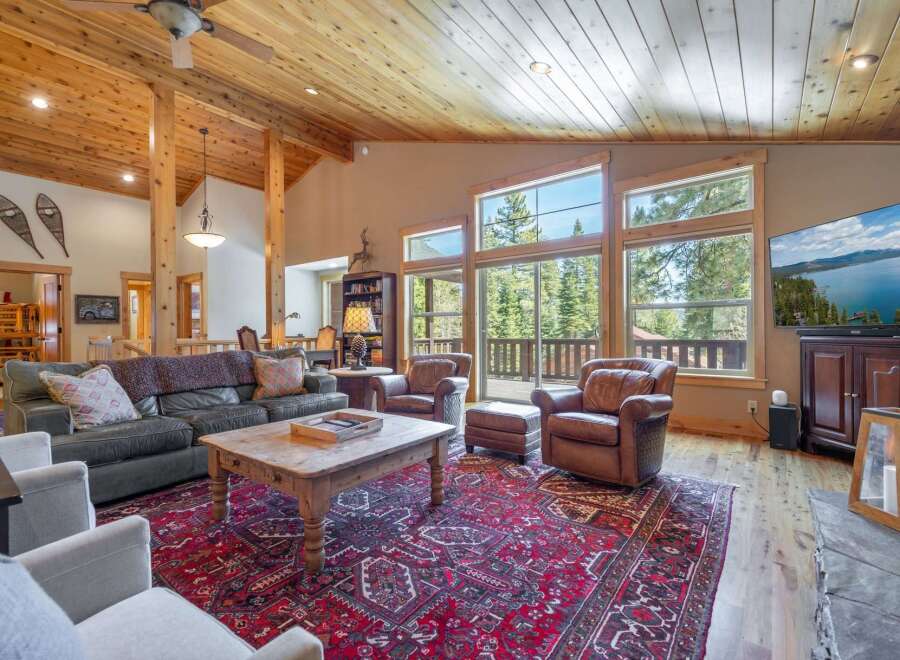 Step into luxury with this stunning living room, featuring a cozy seating area and a beautiful red rug.