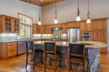 This stunning kitchen boasts custom cabinetry, stainless steel appliances, and a spacious island with a stone base.