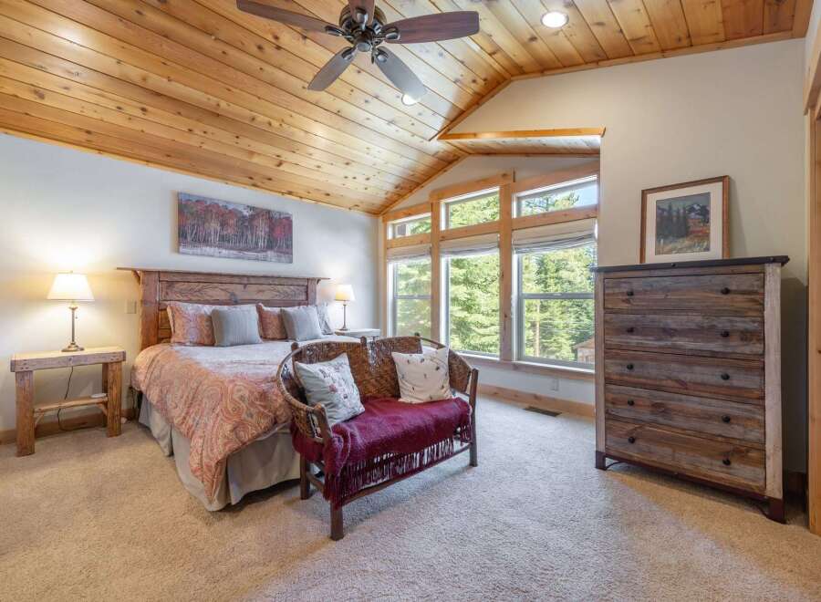 This stunning bedroom boasts a rustic charm with its wooden ceiling and furniture.