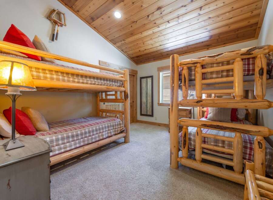 Step into this cozy bedroom featuring rustic bunk beds, perfect for accommodating guests or family.