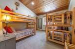 Step into this cozy bedroom featuring rustic bunk beds, perfect for accommodating guests or family.