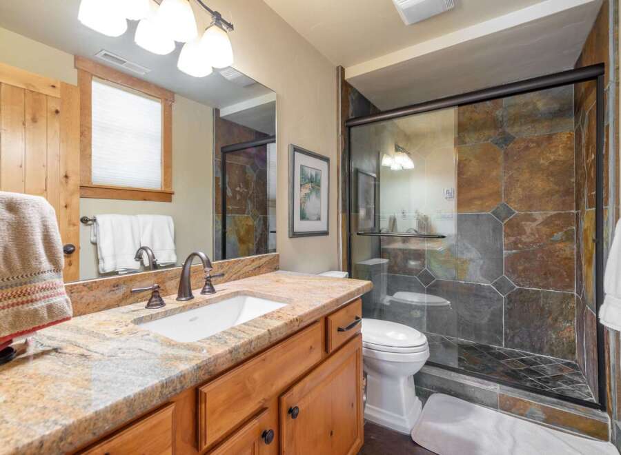 This stunning bathroom boasts a luxurious design with a granite countertop and a spacious shower.