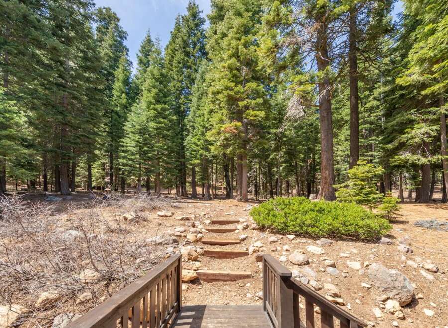 Discover the tranquility of this stunning property surrounded by lush greenery and towering trees.