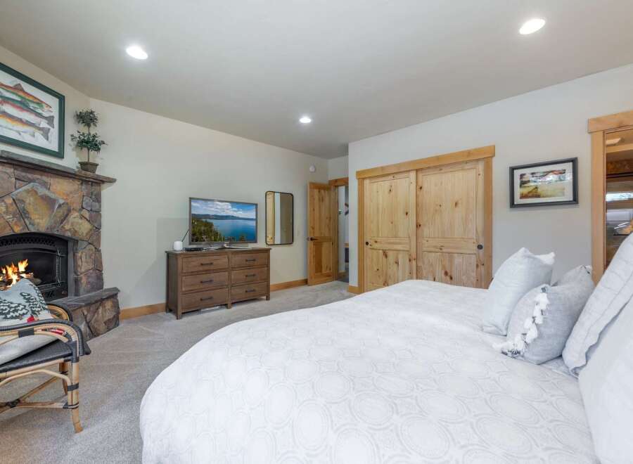 Step into luxury with this stunning bedroom featuring a cozy fireplace and a large, comfortable bed.