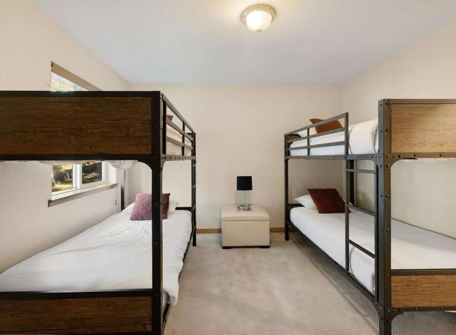 This cozy bedroom features two sets of bunk beds, perfect for accommodating guests or family members.