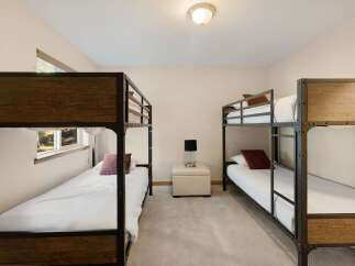 This cozy bedroom features two sets of bunk beds, perfect for accommodating guests or family members.