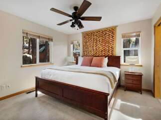 This cozy bedroom features a beautiful wooden bed frame and a stylish ceiling fan.