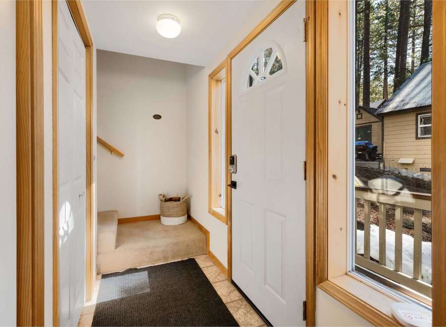 Step into this inviting entryway, featuring a bright white door with a charming arched window.