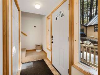 Step into this inviting entryway, featuring a bright white door with a charming arched window.