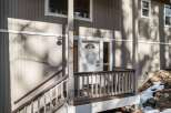 This charming property boasts a welcoming entrance with a covered porch and a stylish white door.