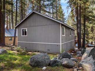 Nestled amidst towering trees, this charming property offers a serene escape.