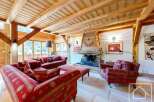 Experience luxury living in this stunning property, featuring a cozy living room with a fireplace and elegant red sofas.