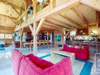 Experience the charm of this stunning chalet, featuring a spacious open-plan living area with exposed wooden beams and a cozy fireplace.