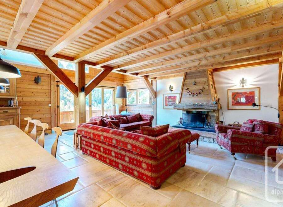 Experience the charm of this stunning property, featuring a cozy living room with a fireplace and exposed wooden beams.