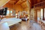 Step into this charming chalet-style bedroom, boasting a warm and inviting ambiance with its wooden walls and floors.
