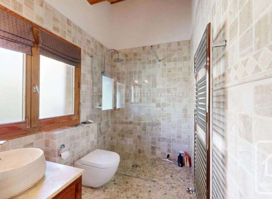 This stunning bathroom features a luxurious design with a walk-in shower, a modern toilet, and a stylish sink.