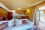 Experience the charm of this cozy alpine property, featuring a warm wooden interior and a comfortable living space.