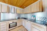 This stunning kitchen boasts a modern design with sleek countertops and light wood cabinetry.