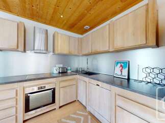 This stunning kitchen boasts a modern design with sleek countertops and light wood cabinetry.