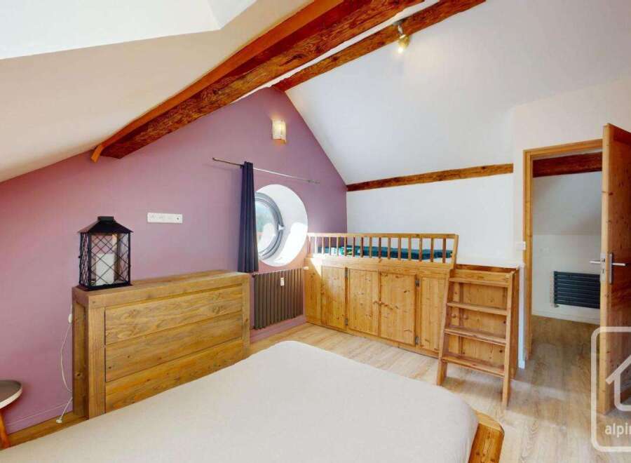 This charming bedroom features a unique design with exposed wooden beams and a cozy atmosphere.