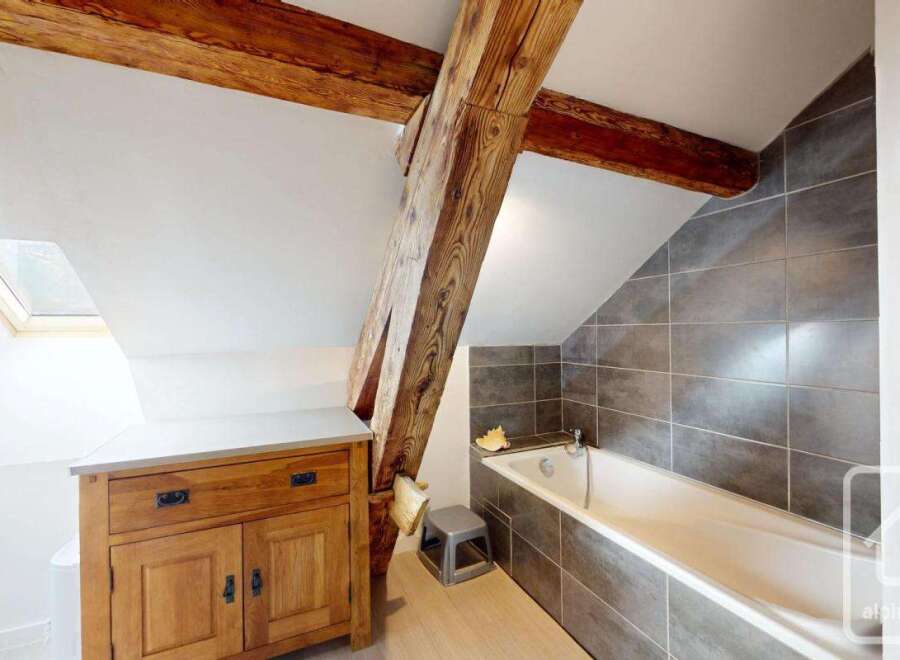 Discover the charm of this unique bathroom featuring exposed wooden beams and a stylish design.